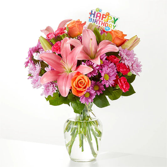 A vibrant birthday mix flower vase filled with an assortment of colorful flowers like roses, sunflowers, and tulips, celebrating the occasion with brightness and joy.