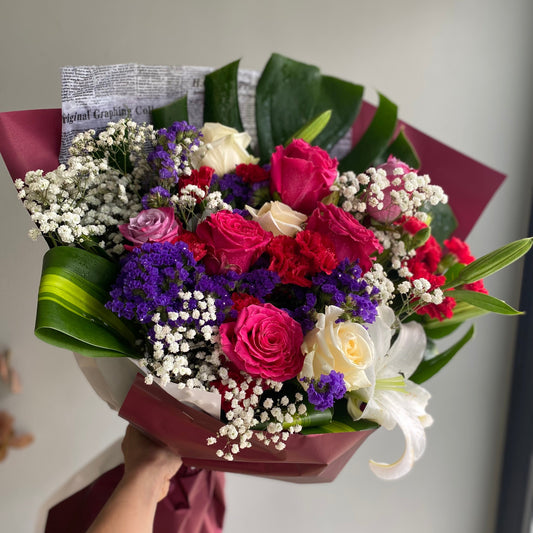 A vibrant birthday mix bouquet featuring an assortment of colorful flowers like roses, lilies, daisies, and carnations, arranged to celebrate a special occasion with cheer and joy.