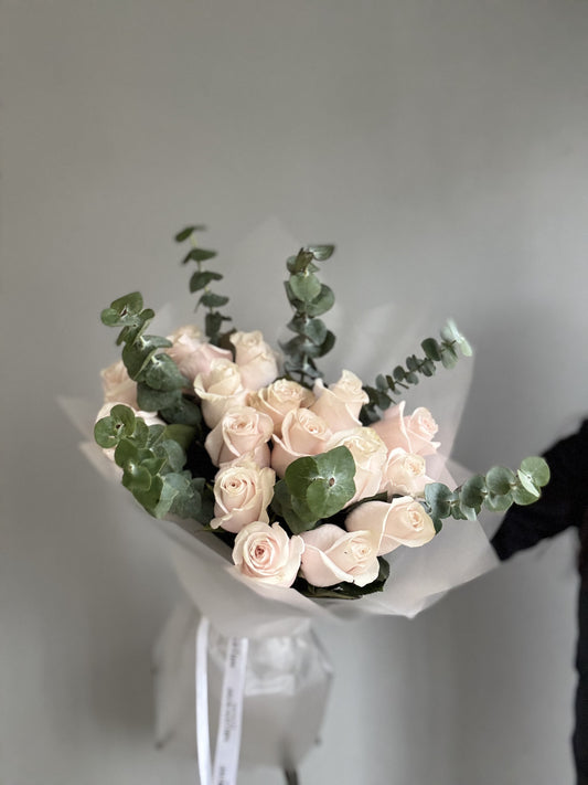 A Pink Blush Bouquet featuring soft pink and blush-colored roses, peonies, and baby’s breath, arranged delicately to create a romantic and elegant floral display.