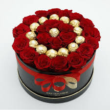 A Red Roses and Chocolate Flower Box featuring vibrant red roses arranged with an assortment of luxurious chocolates, creating a perfect gift of love and indulgence.
