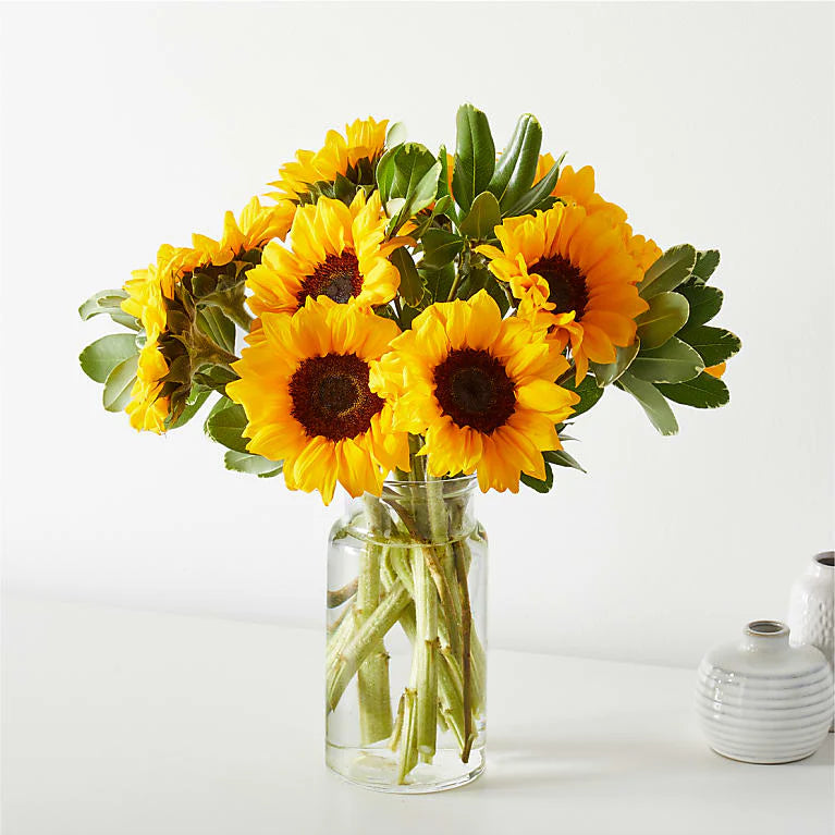 A Sunny Sunflowers Bouquet featuring vibrant yellow sunflowers arranged with fresh greenery and soft filler flowers, creating a cheerful and bright floral display. 