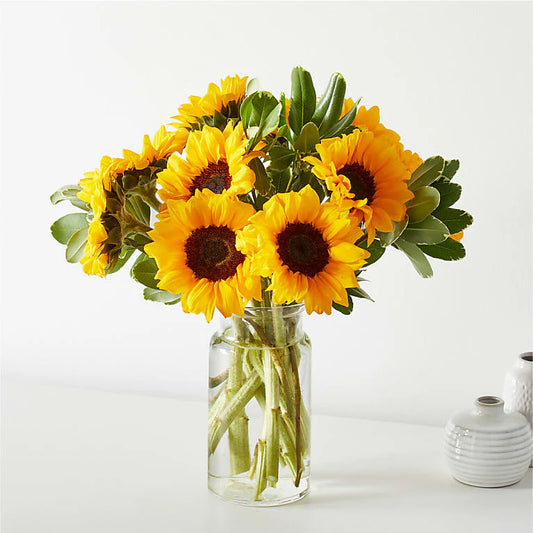 A Sunny Sunflowers Bouquet featuring vibrant yellow sunflowers arranged with fresh greenery and soft filler flowers, creating a cheerful and bright floral display. 